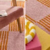 Alfombra interior con patrón damero naranja y rosa