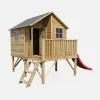 Cabaña infantil de madera sobre postes con tobogán