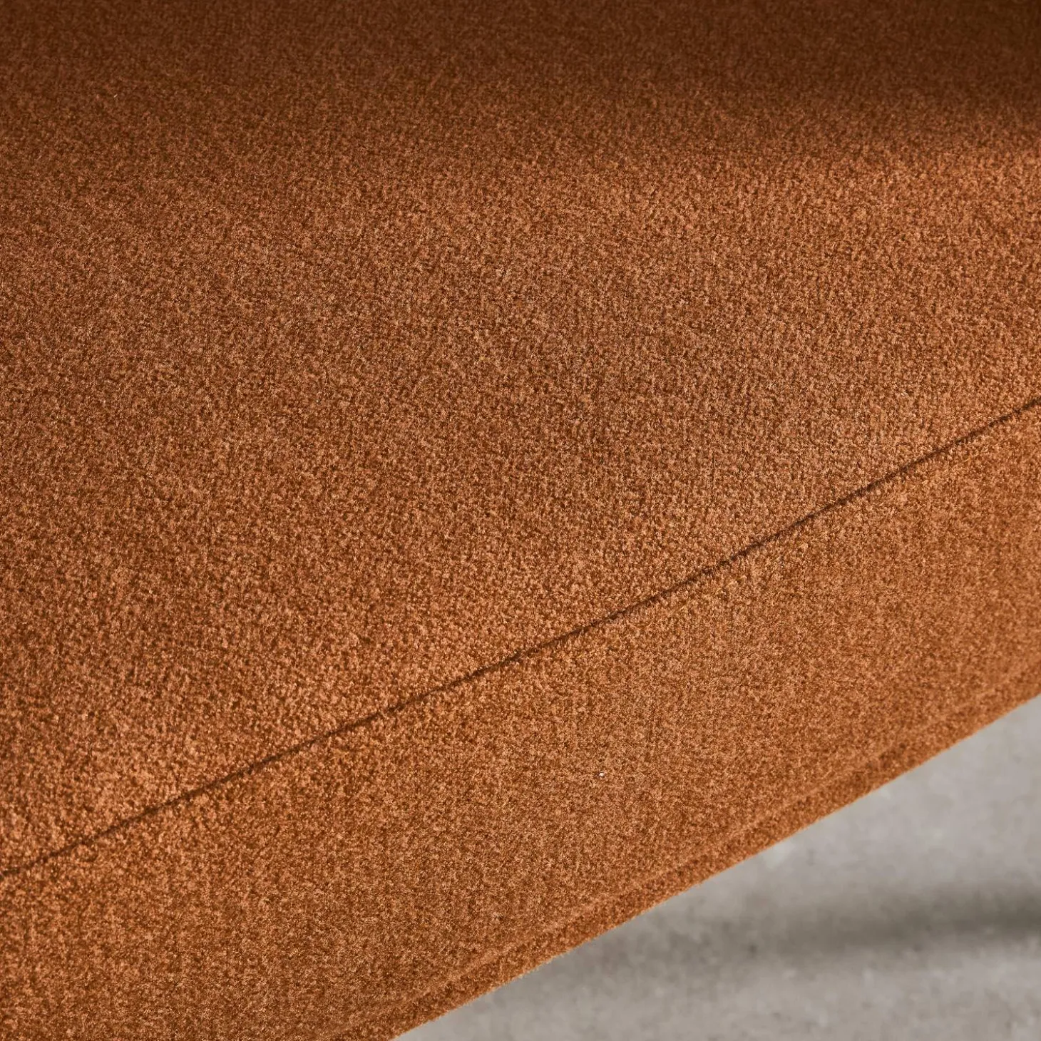 Sillón de tela con respaldo curvo y patas de metal