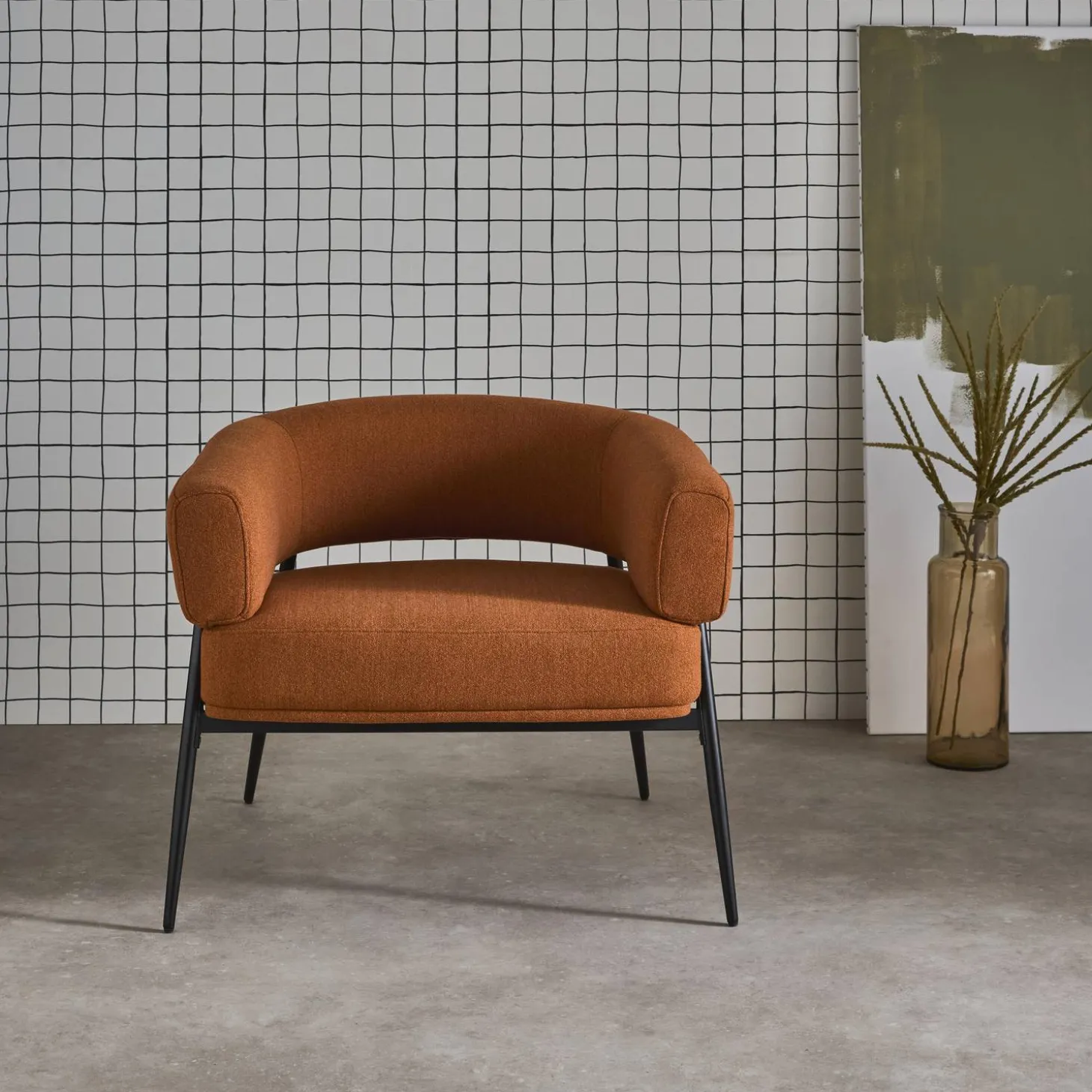 Sillón de tela con respaldo curvo y patas de metal