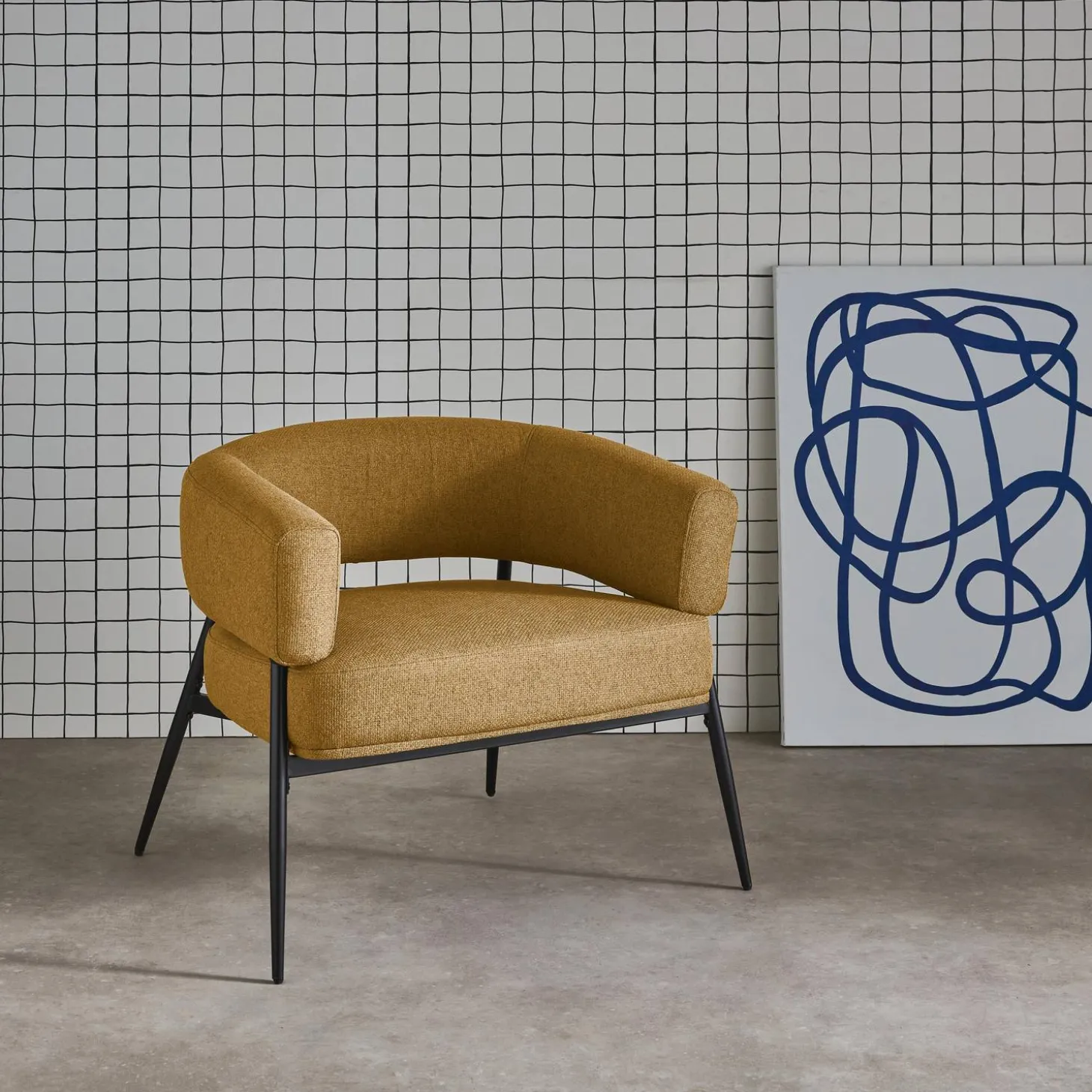 Sillón de tela con respaldo curvo y patas de metal