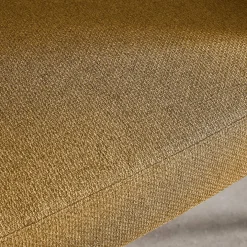 Sillón de tela con respaldo curvo y patas de metal