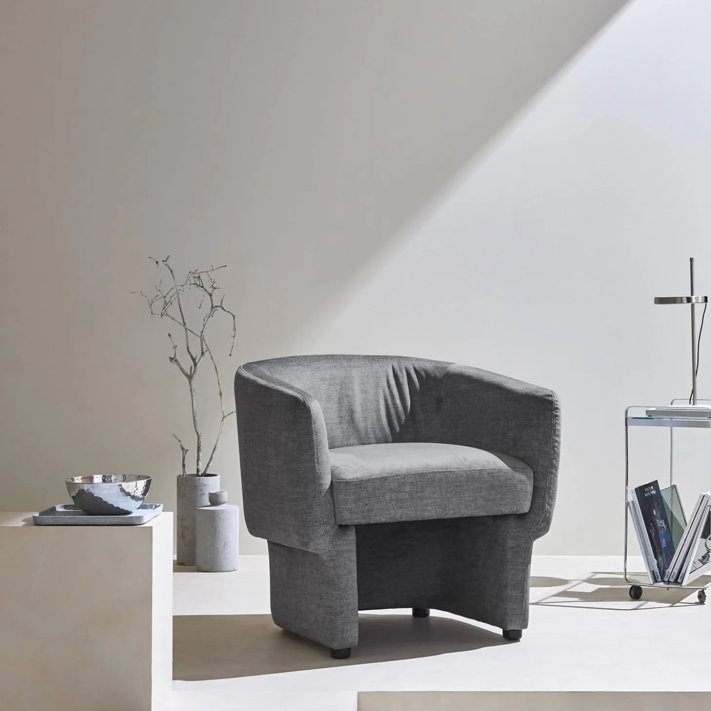 Sillón de tela con respaldo y base redondeada