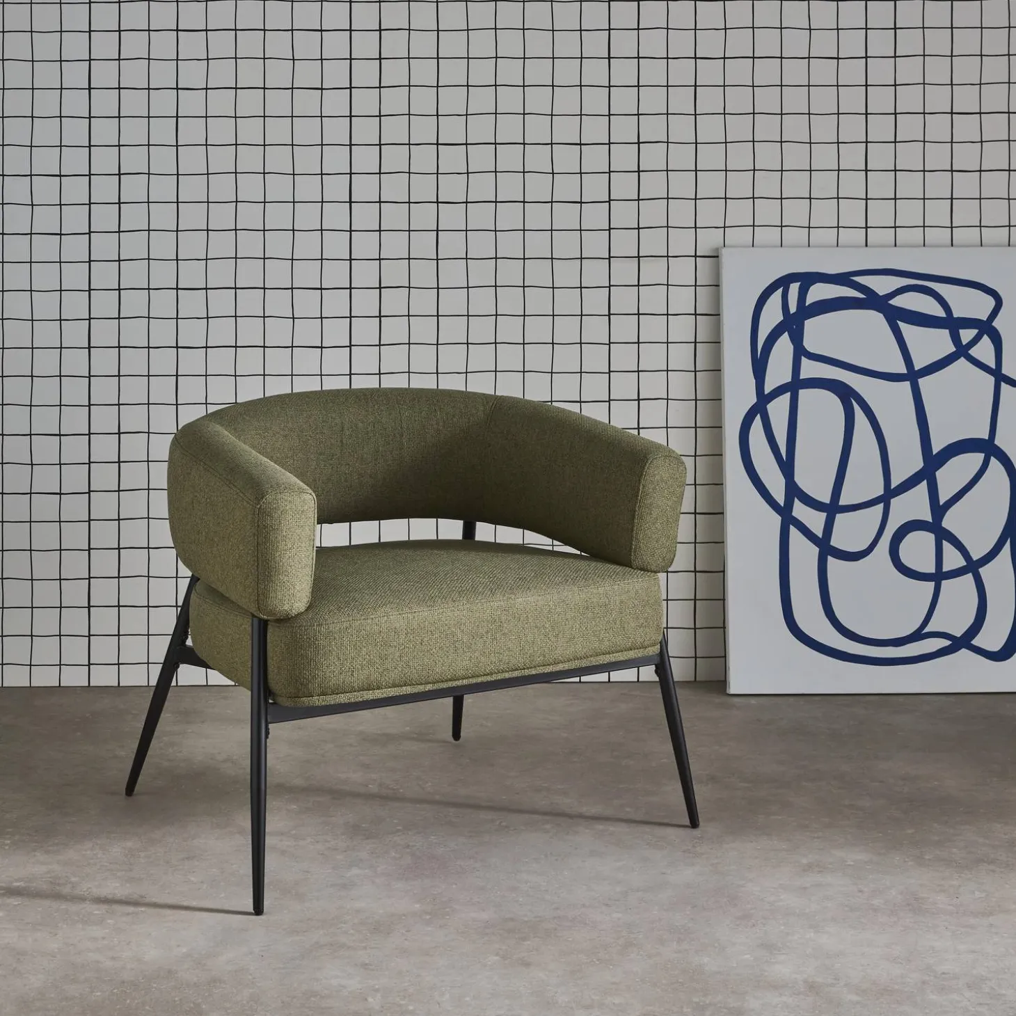 Sillón de tela con respaldo curvo y patas de metal
