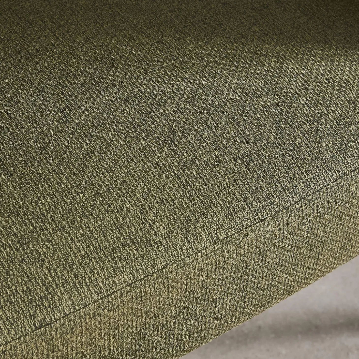 Sillón de tela con respaldo curvo y patas de metal