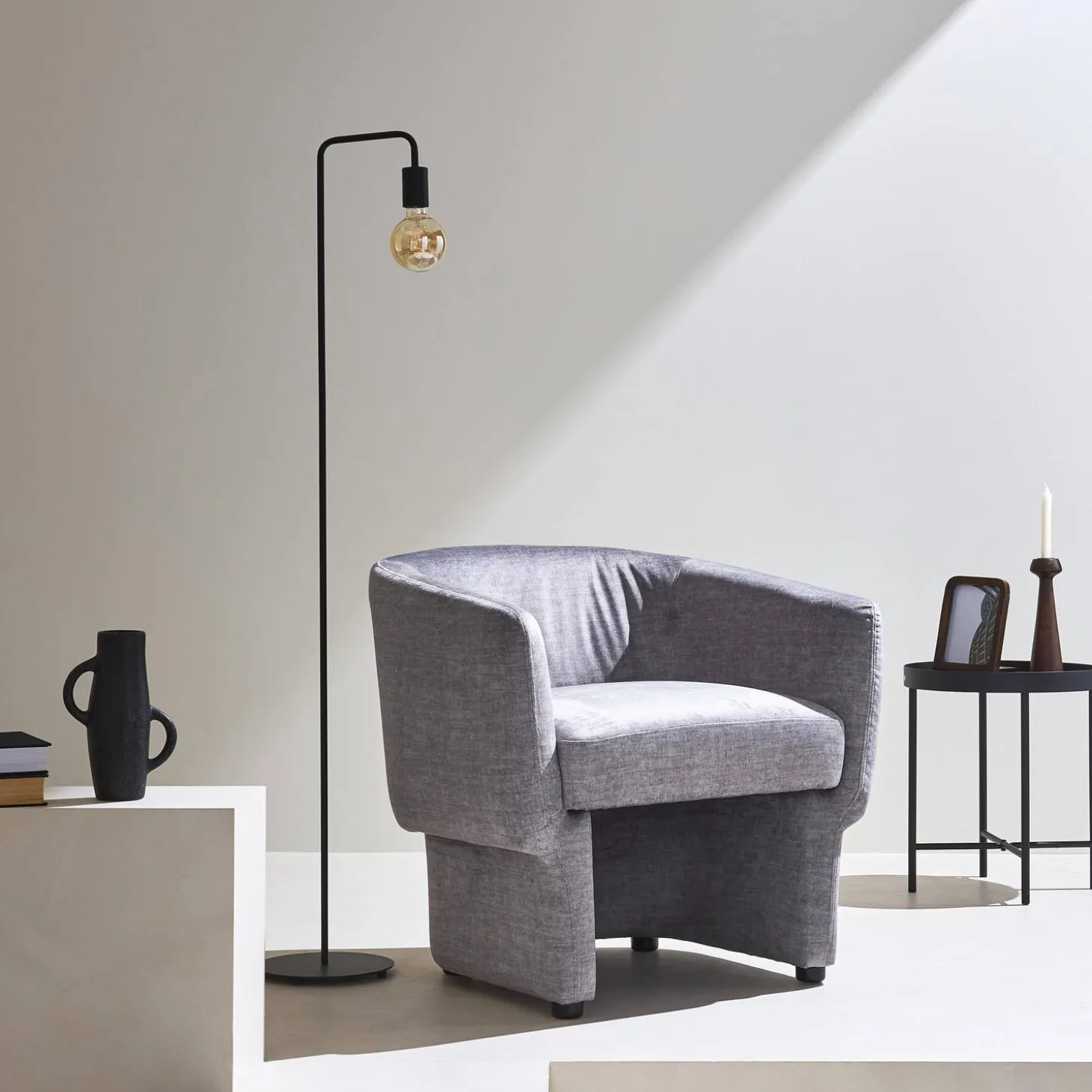 Sillón de tela con respaldo y base redondeada